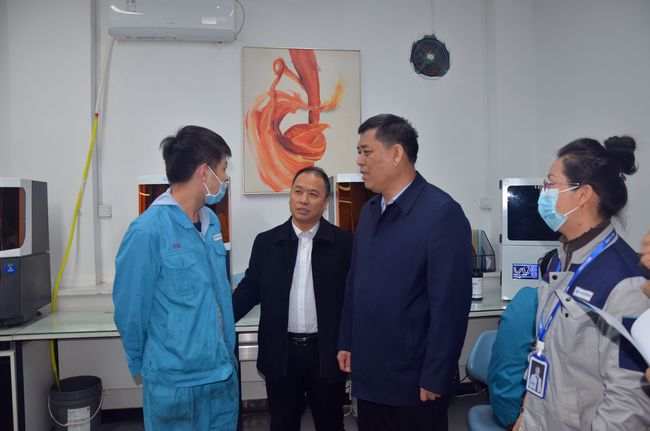 图为山西省残联党组成员、副理事长李俊温与恒伦口腔教育专修学院安置的残疾学员交流