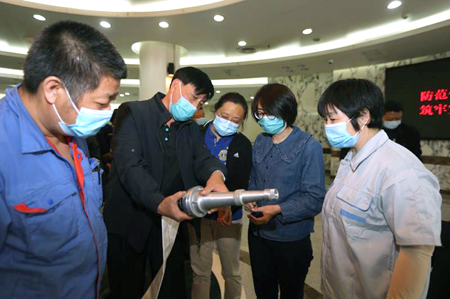 图为参会人员进行消防栓连接、灭火器明火扑救演练