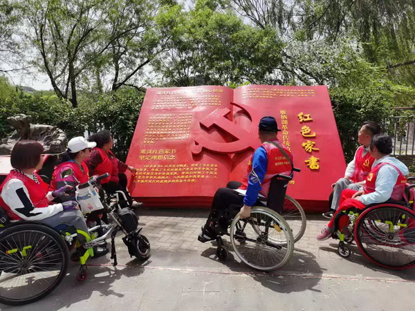 图为残疾人阅读红色家书