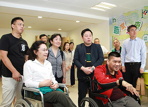 图为张海迪在澳门扶康会认真听取工作人员介绍