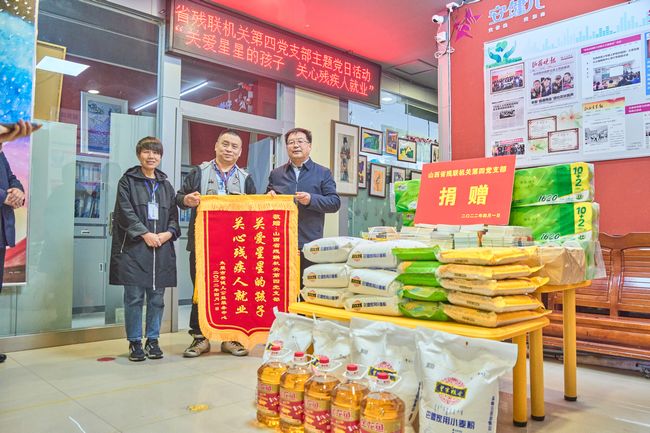 图为太原安健儿公益服务中心向山西省残联机关第四党支部赠送锦旗