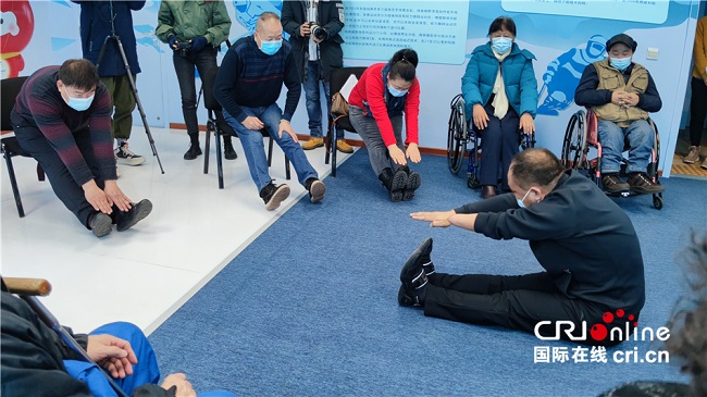 图为残疾人退役运动员指导康复操