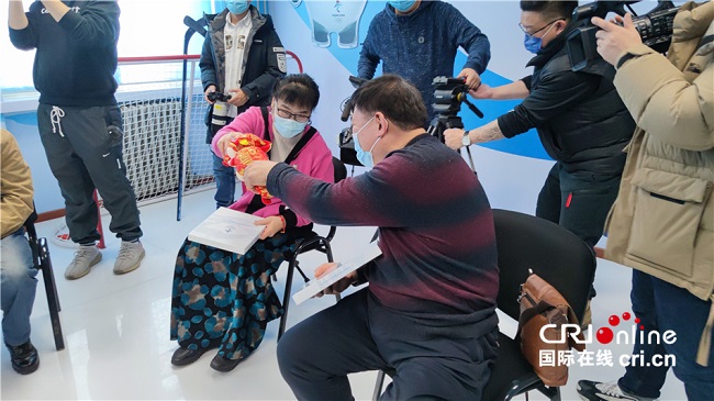 图为现场为残疾人发放礼品