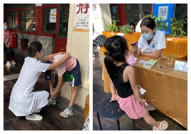 图为医务人员为义诊儿童检诊