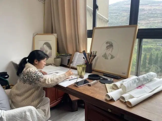 图为陈露园在画室画画
