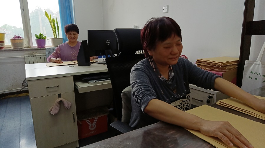 图为盲人老师正在质检盲文版会议材料