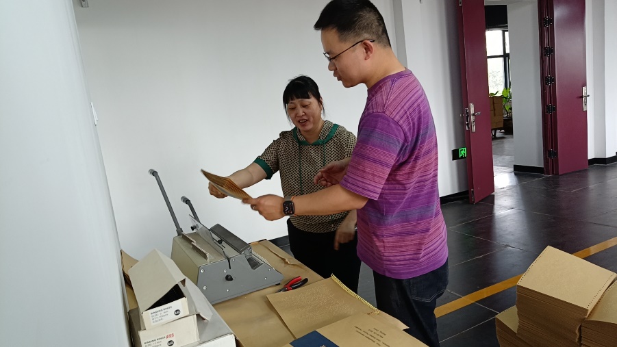 图为印制部的老师正在装订盲文版会议材料