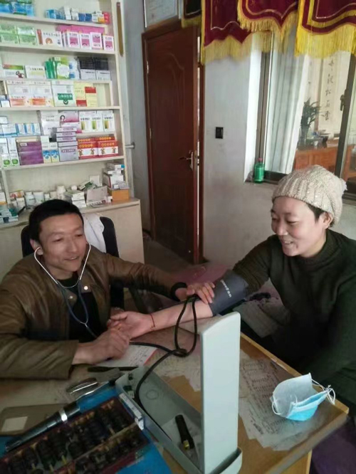图为马启红在诊治病患