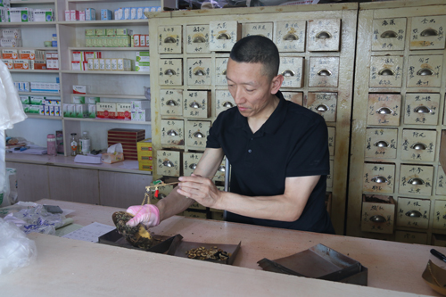 图为马启红为病患精心配药