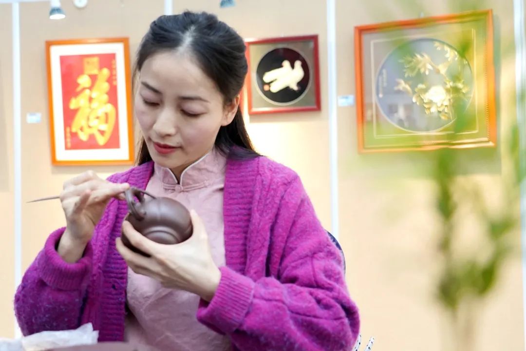 图为袁露露在展览现场为观众表演了紫砂贴花的技艺