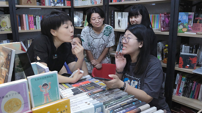 图为康复老师指导听力残疾人发音