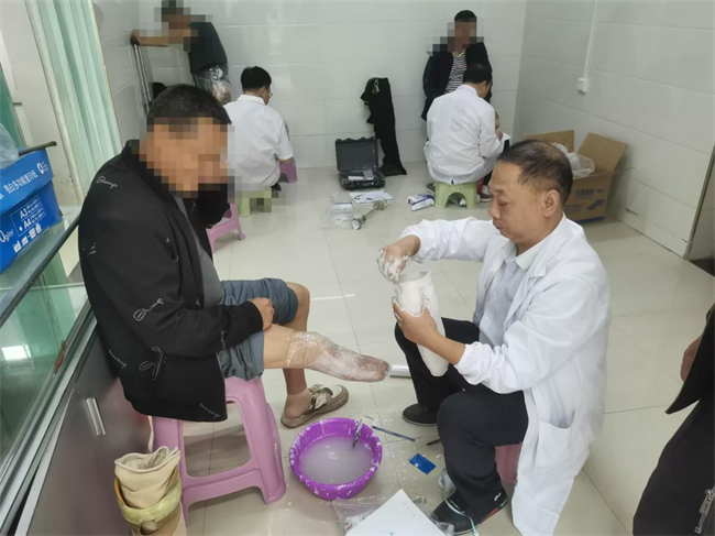 图为工作人员为残疾人免费适配假肢取模服务