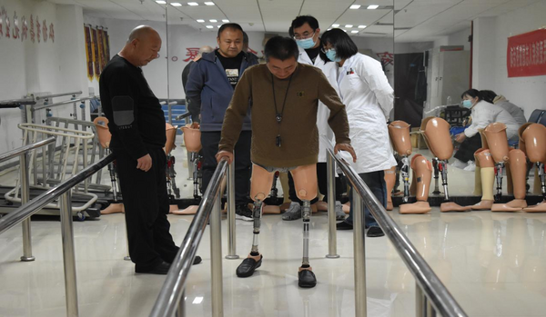 图为残疾人在活动中进行假肢适应性训练