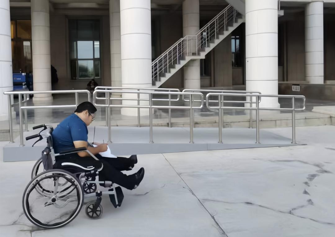 严宇桥在主楼正门记录无障碍坡道测绘数据