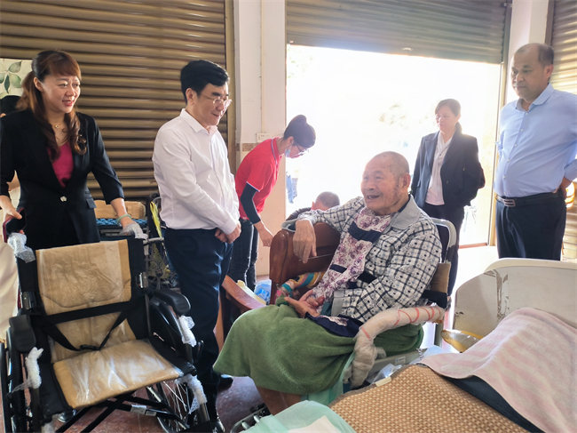 图为自治区残联许健强副理事长到残疾边民家中慰问并送上免费配发的辅具