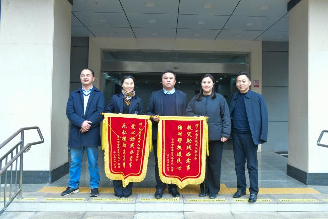 图为资兴市健辉服饰有限公司与资兴市果农富农业科技有限公司为省残联赠送锦旗