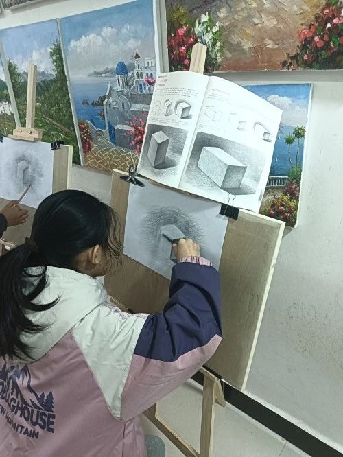 图为在黄晓旺工作室绘画的孩子