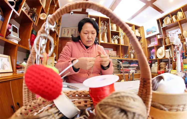 图为李忠慧用棕叶编工艺品