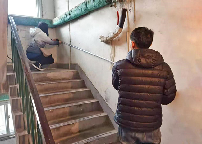 图为南开区残联现场测量楼道无障碍扶手