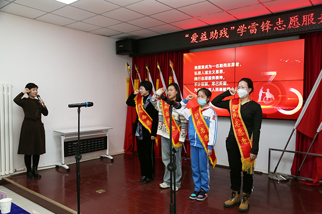 图为天津市优秀志愿者代表曲蕾带领志愿者们庄严宣誓