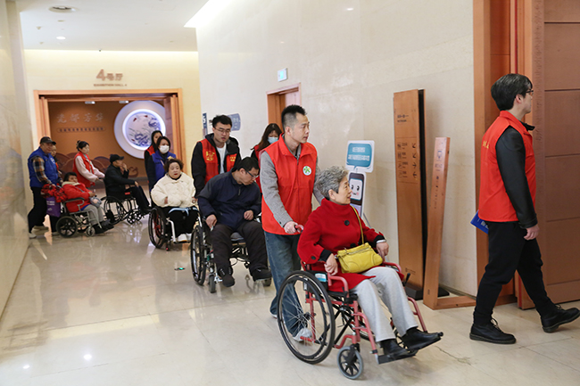 图为助残志愿者带领残疾朋友们体验馆内无障碍设施