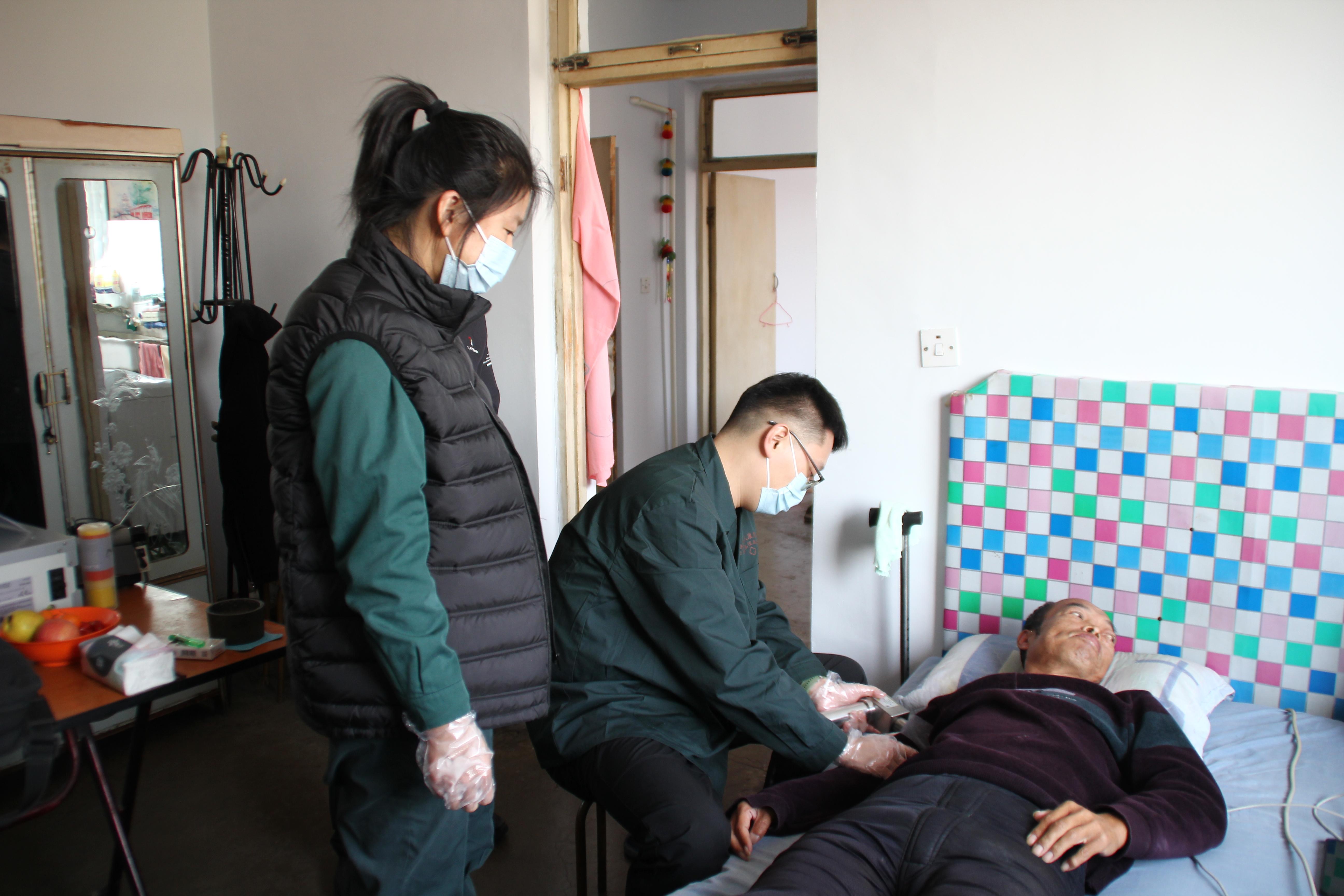 图为入户为残疾人康复治疗