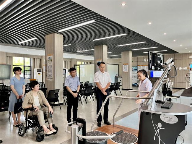 图为尹华凯在长沙民政职业技术学院健康养老大楼考察智慧健康养老服务与管理专业建设情况