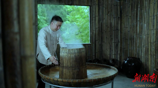 图为陈历祥用传统方法酿酒