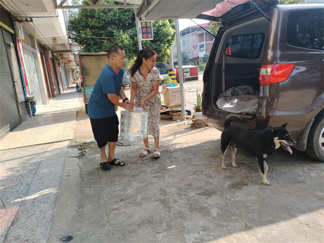 图为周长春和王文兰携手将酒进行装车