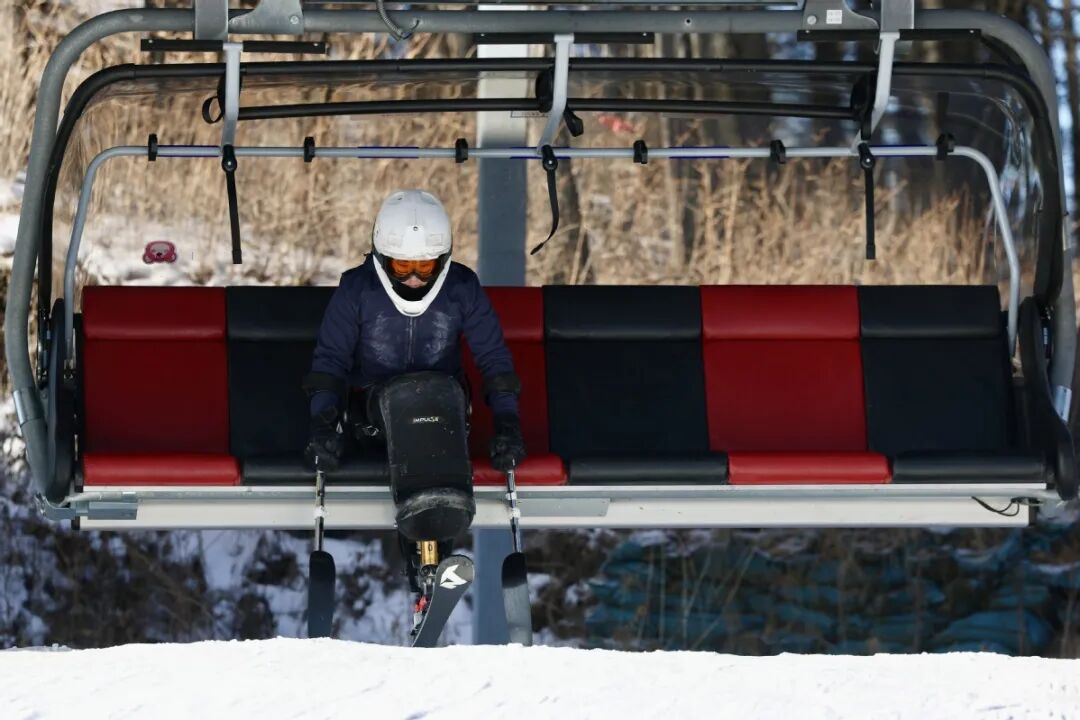 图为国家残奥高山滑雪队队员坐缆车抵达山顶