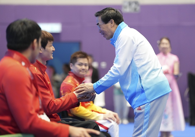 图为全国政协常委、中国残联主席程凯(右)看望残特奥会香港赛区运动员