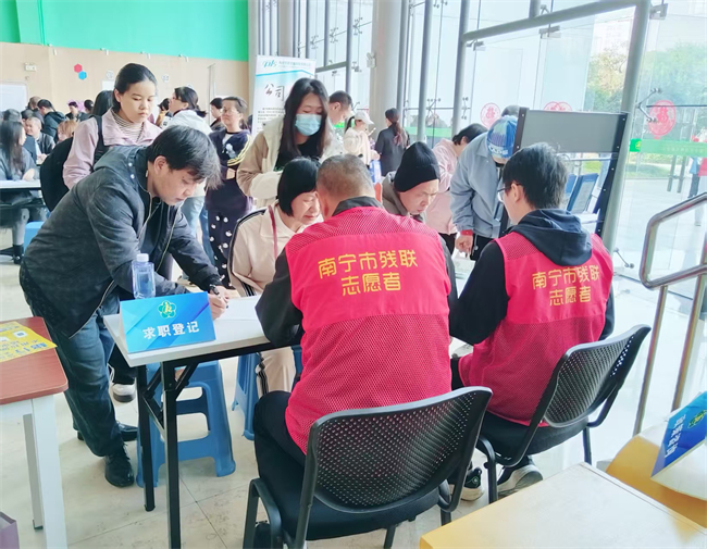 图为志愿者为残疾人提供求职登记服务