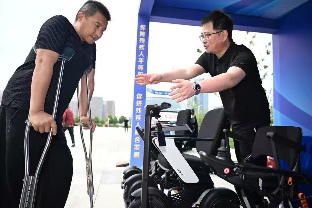 图为向残疾人介绍电动轮椅等辅助器材 图为向残疾人介绍电动轮椅等辅助器材