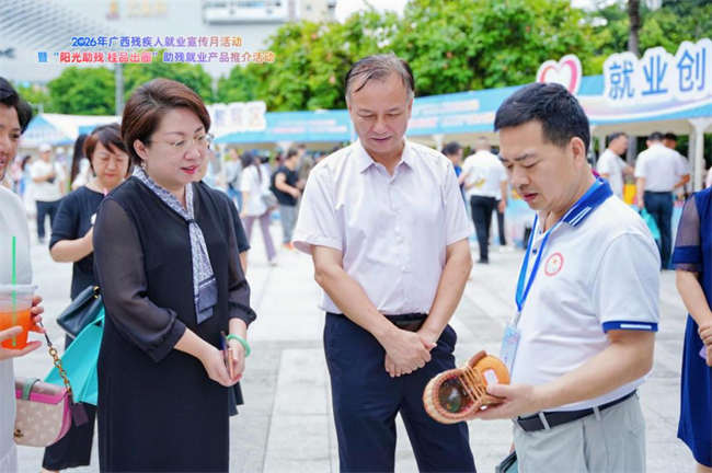 图为广西残联党组成员、副理事长陶洪新、宁宇与助残就业企业负责人交谈
