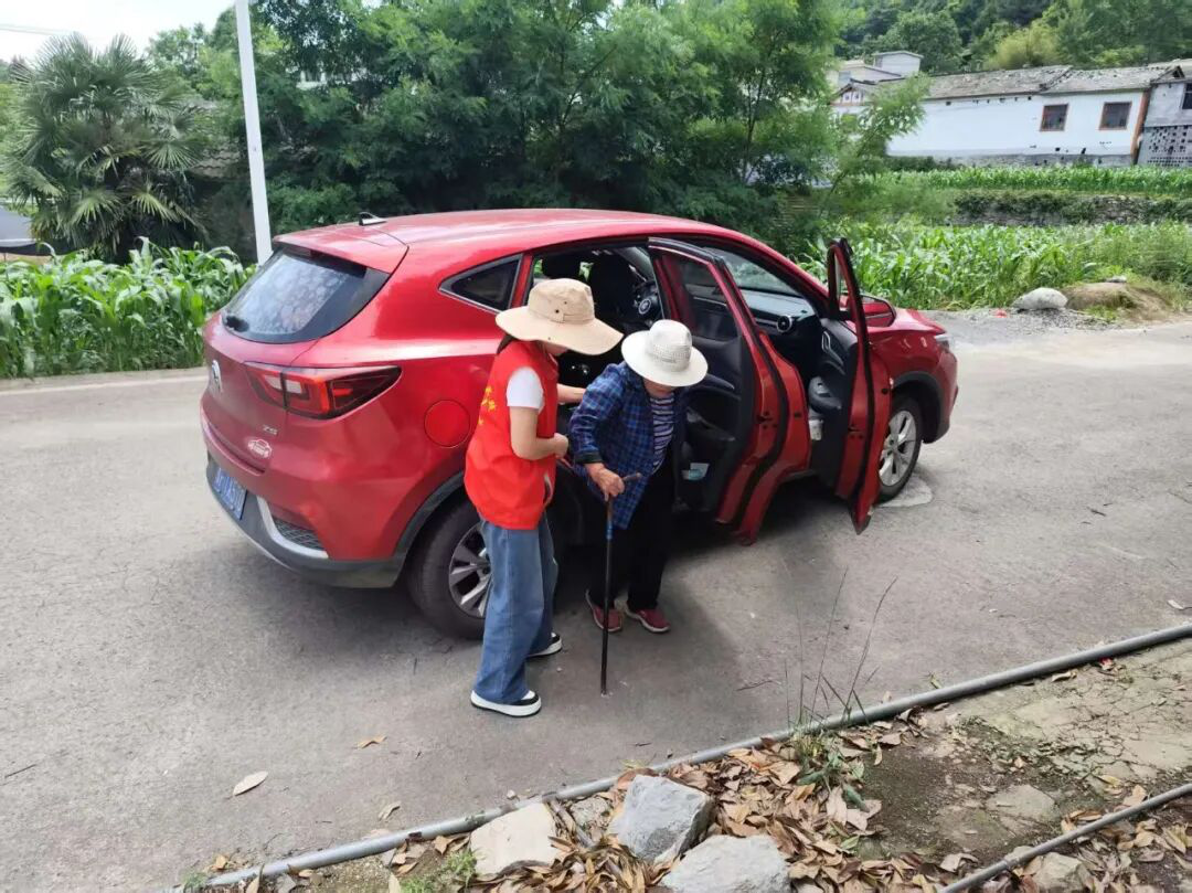 图为志愿者接行动不便的老人 图为志愿者接行动不便的老人