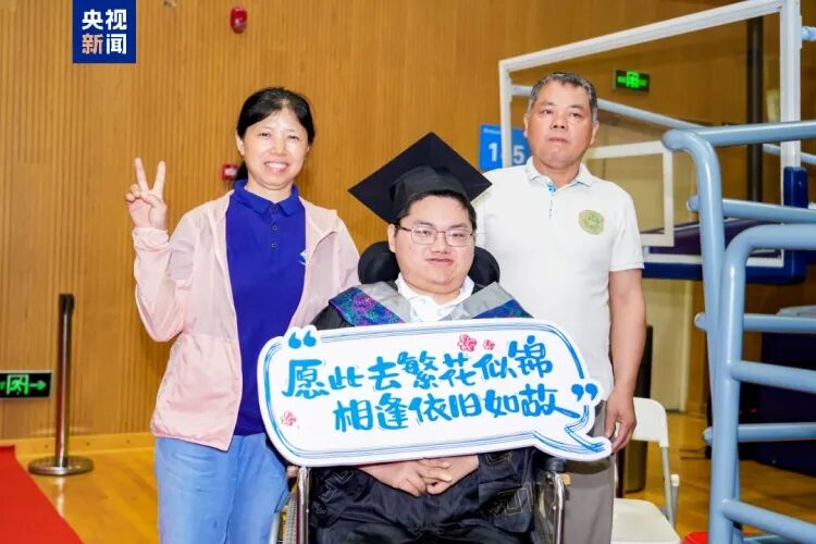 图为周俊章父母陪他参加毕业典礼 图为周俊章父母陪他参加毕业典礼