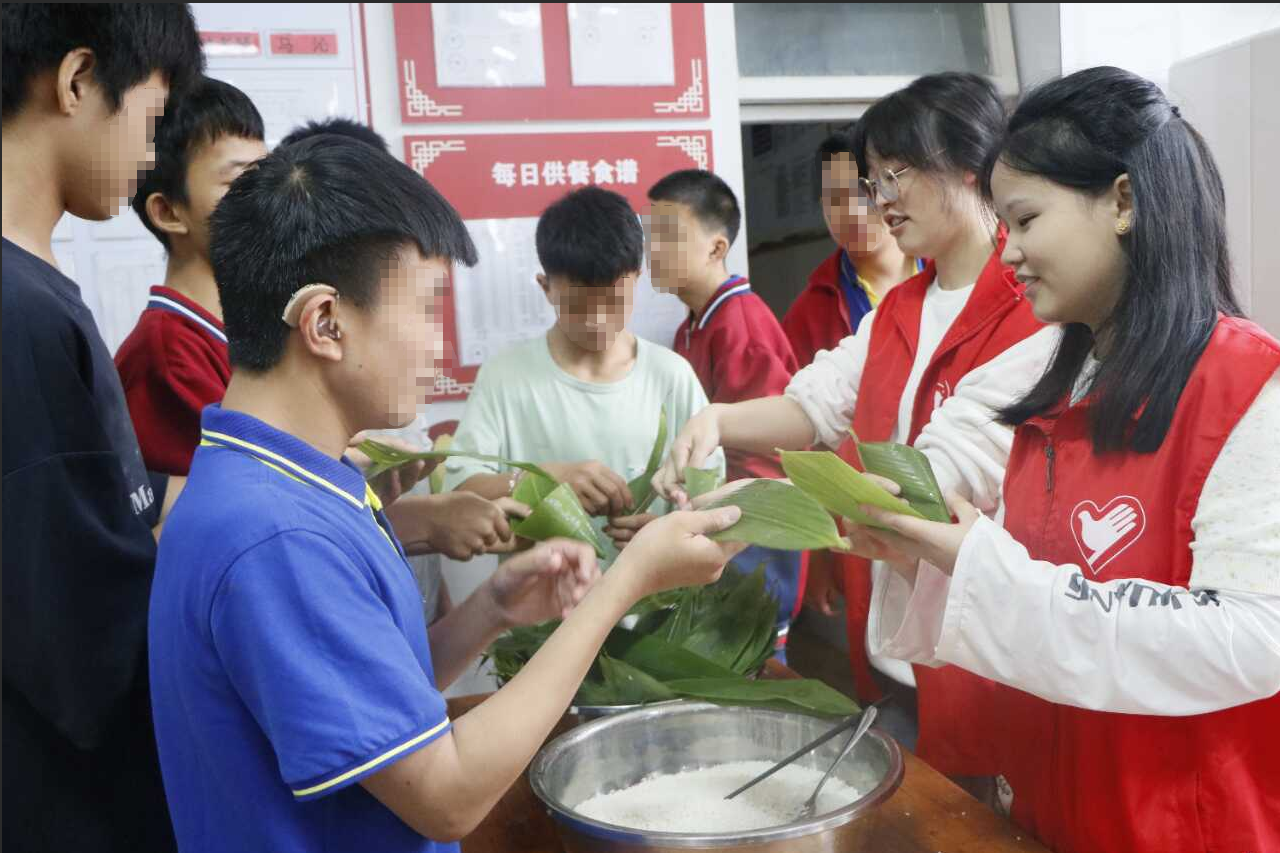 图为包粽子现场