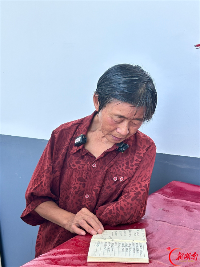 图为黄玉香向记者展示账本。